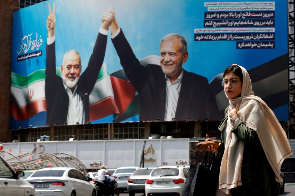 لوحة كبيرة في طهران في الثامن من آب/أغسطس 2024 يظهر فيها الرئيس الإيراني مسعود بيزشكيان وقائد حركة حماس اسماعيل هنية الذي قتل في طهران (ا ف ب)   