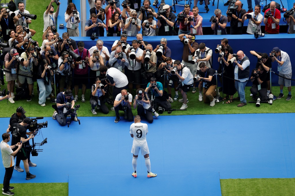 الفرنسي كيليان مبابي يقف أمام المصوّرين في ظهوره الأول بقميص ريال مدريد الإسباني على ملعب سانتياغو برنابيو. مدريد في 16 تموز/يوليو 2024 (ا ف ب)
