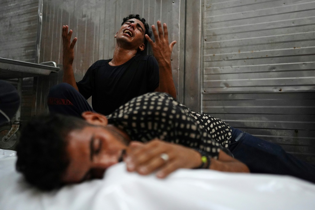فلسطينيان يبكون قريبا قتل في غارة إسرائيلية في خان يونس في جنوب قطاع غزة في 12 آب/أغسطس 2024 (ا ف ب)