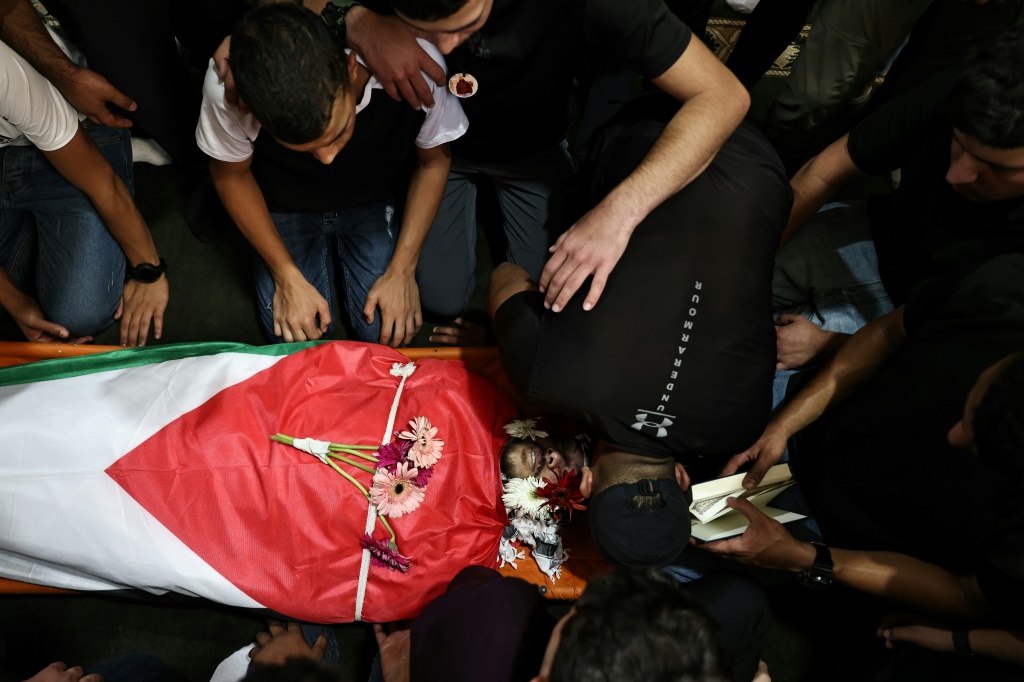 مشاركون في جنازة الفلسطيني معتز صرصور في مخيم الأمعري للاجئين قرب مدينة رام الله بالضفة الغربية المحتلة في 13 آب/أغسطس 2024، بعد أن قتلته قوات الاحتلال الإسرائيلي (أ ف ب)   