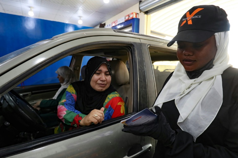 السودانية أساور مصطفى تقدّم خدمات لزبونة في كاراج للسيارات في مصراتة في ليبيا في 31 تموز/يوليو 2024 (أ ف ب)