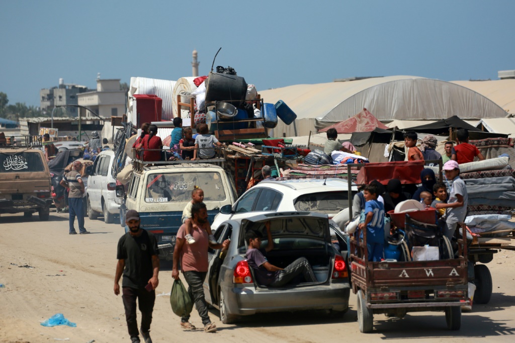 نازحون فلسطينيون يفرون من مخيم أقيم في خان يونس في جنوب قطاع غزة في 18 آب/أغسطس 2024 بعدما تمركزت دبابات إسرائيلية بجواره (ا ف ب)