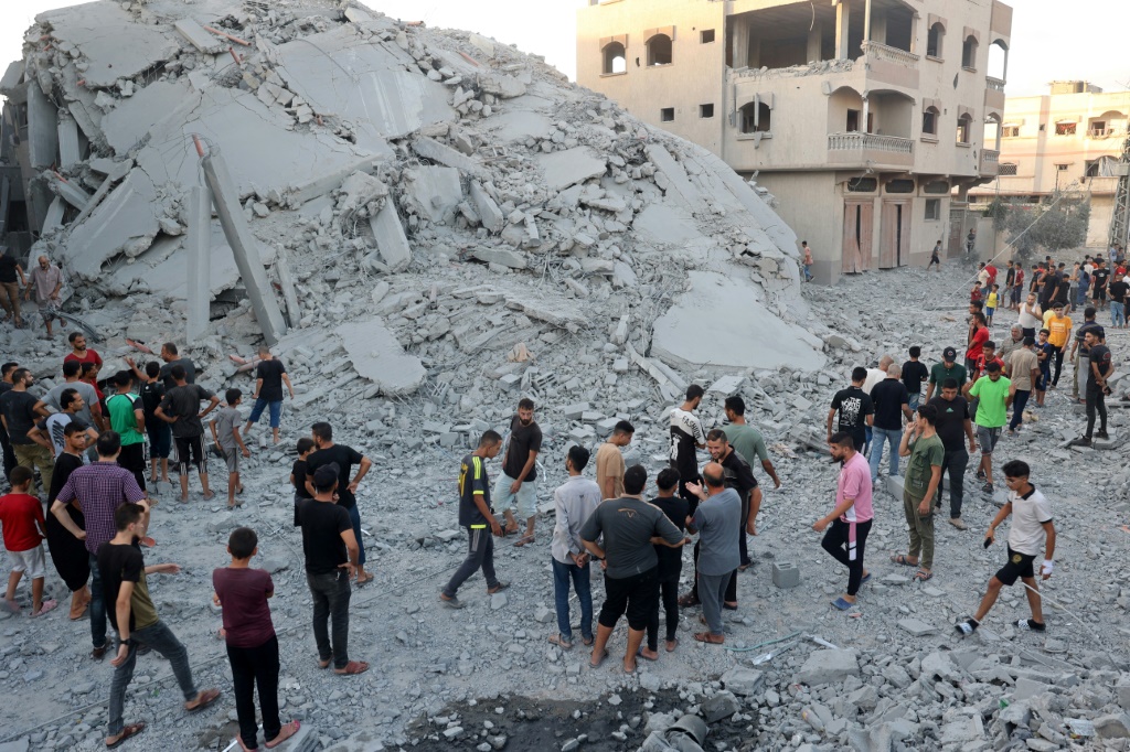    فلسطينيون يتفقدون بقايا مبنى بعد وقت قصير من قصف إسرائيلي دمره في مخيم النصيرات للاجئين وسط غزة (أ ف ب)   