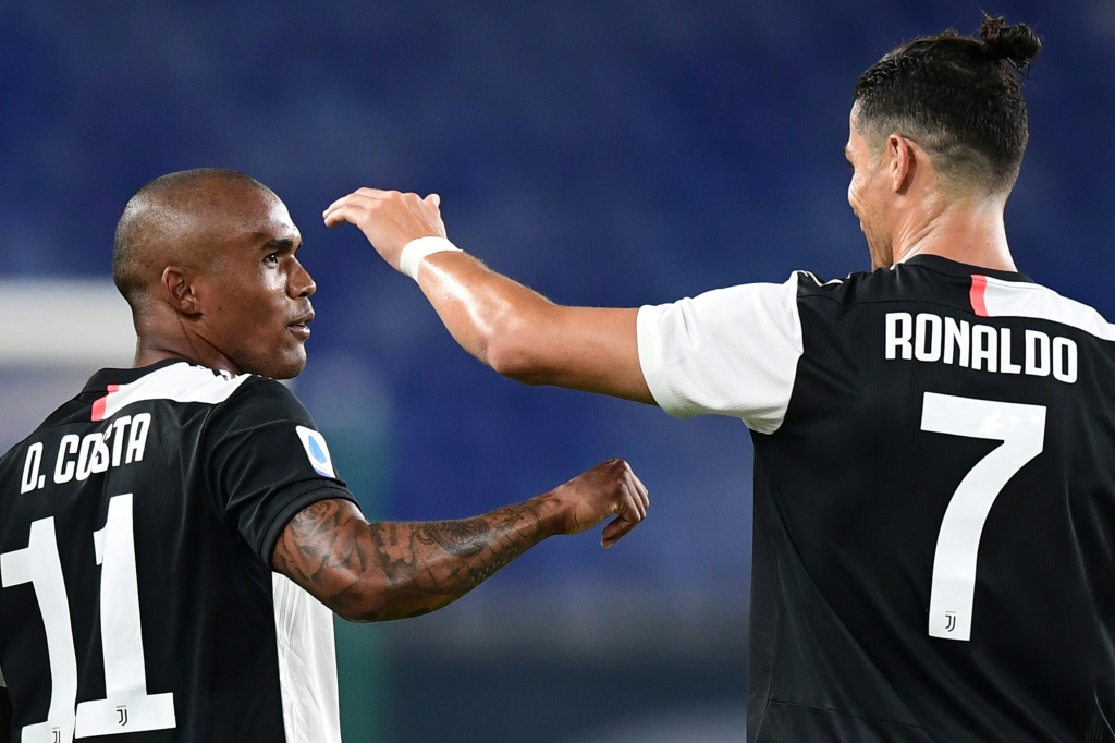 البرازيلي دوغلاس كوستا (إلى اليسار) يحتفل مع زميله في يوفنتوس البرتغالي كريستيانو رونالدو بعد التسجيل أمام جنوى على ملعب لويجي فيراريس في 30 حزيران/يونيو 2020 (ا ف ب)