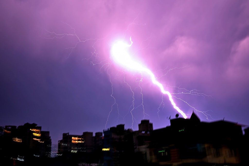 البرق يضيء سماء الليل أثناء عاصفة في مدينة جواهاتي الهندية في 31 مارس (أ ف ب)   