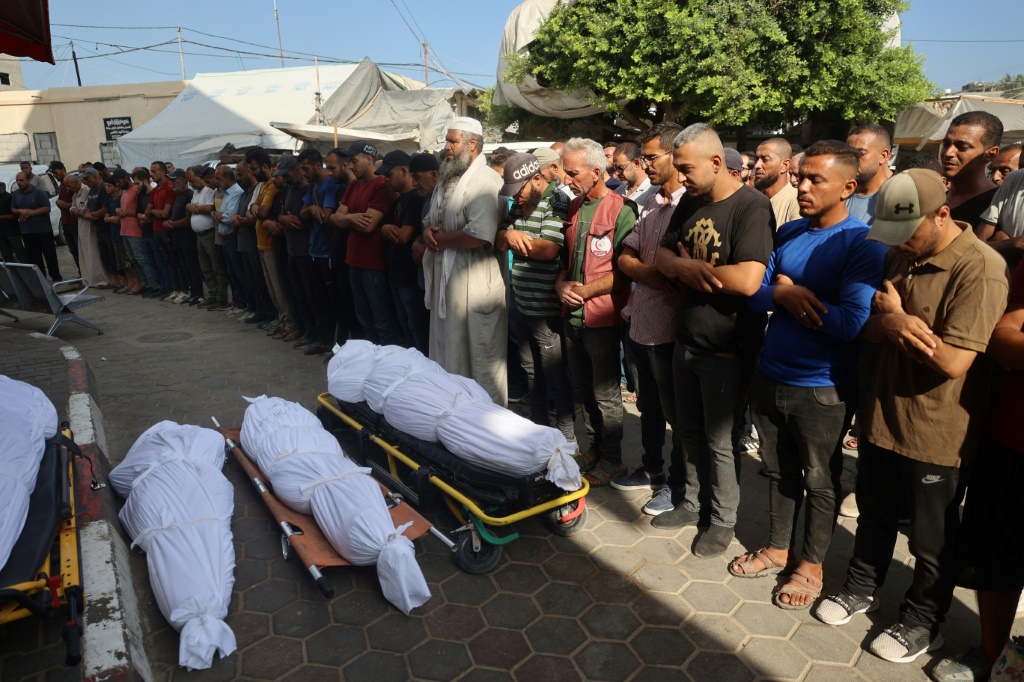 فلسطينيون يشيعون جثامين ضحايا القصف الإسرائيلي على دير البلح وسط قطاع غزة (أ ف ب)   