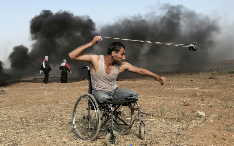 الفلسطيني صابر الأشقر يرشق القوات الإسرائيلية بالحجارة عند الحدود بين قطاع غزة والدولة العبرية في 11 أيار/مايو 2018(أ ف ب)