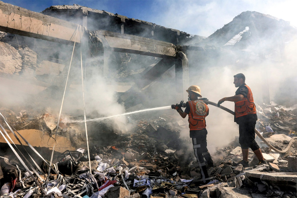 عناصر من الدفاع المدني الفلسطيني يقومون باخماد حريق في مبنى تعرض لقصف اسرائيلي في حي الشيخ رضوان في شمال قطاع غزة في 3 ايلول/سبتمبر 2024. (أ ف ب)