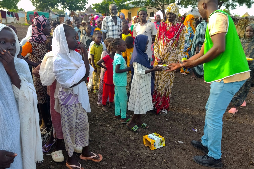 جانب من عملية توزيع حصص غذائية على نازحين سوادنيين في مخيم في القضارف في التاسع من أيلول/سبتمبر 2024 (أ ف ب)   