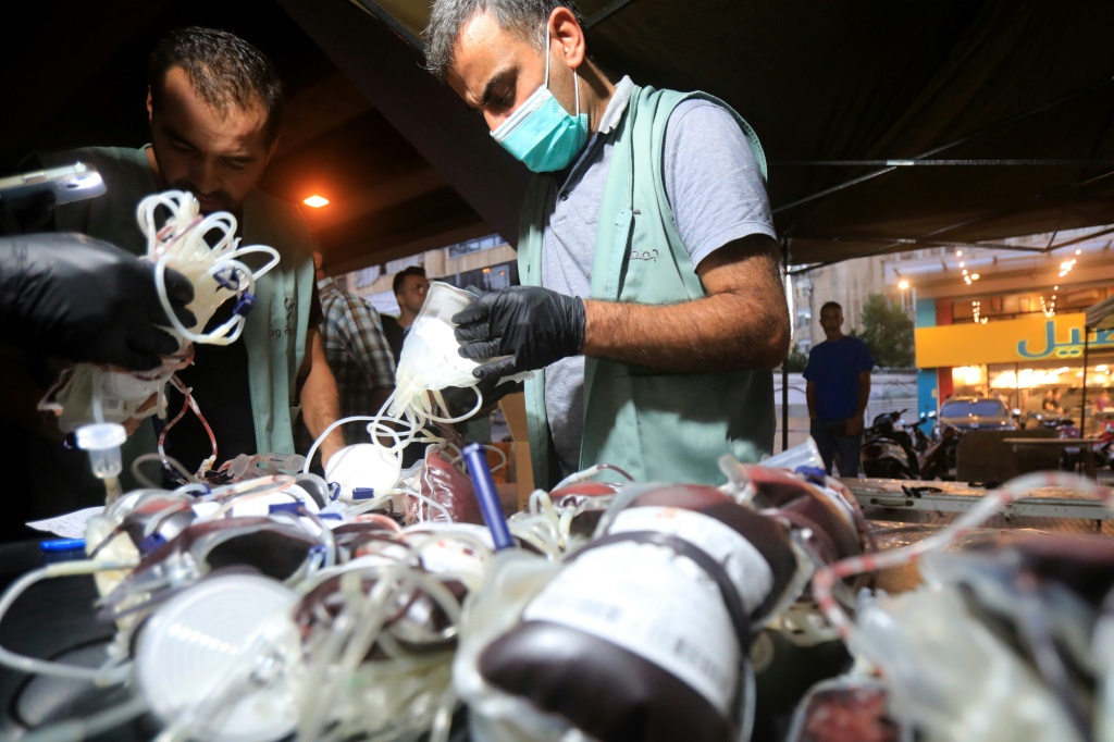 مسعفون يجمعون الدم من متبرعين في الضاحية الجنوبية لبيروت في 17 أيلول/سبتمبر 2024، بعد انفجارات متزامنية لإجهة الاشعار في العديد من معاقل حزب الله وسط تبادل القصف عبر الحدود بين إسرائيل ومقاتلي حزب الله (أ ف ب)   