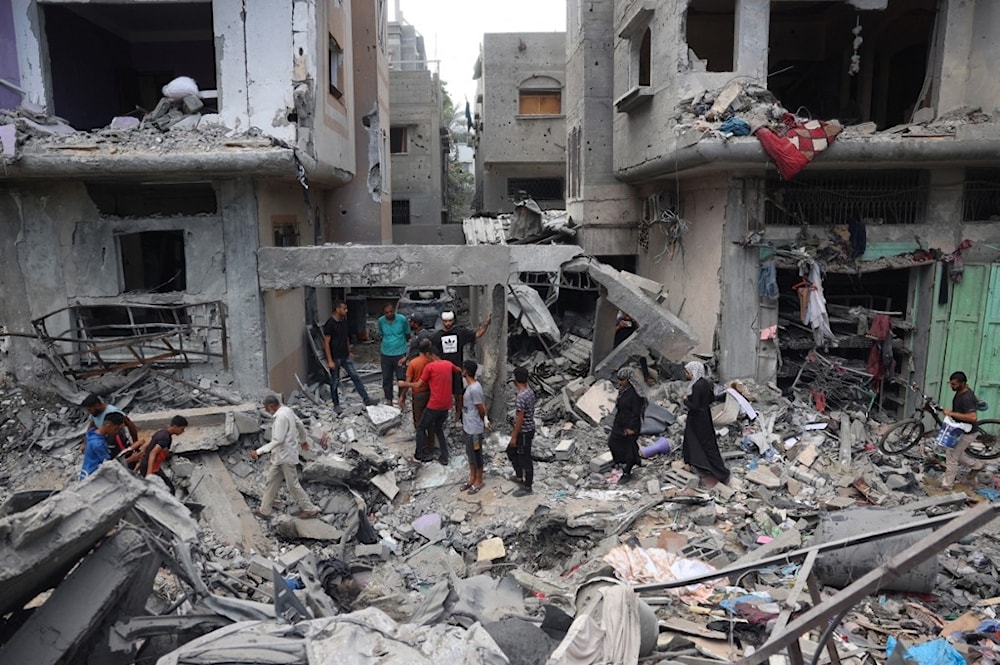 فلسطينيون يسيرون بين الأنقاض في مخيم النصيرات للاجئين في جنوب قطاع غزة 17 سبتمبر 2024 (أ ف ب)