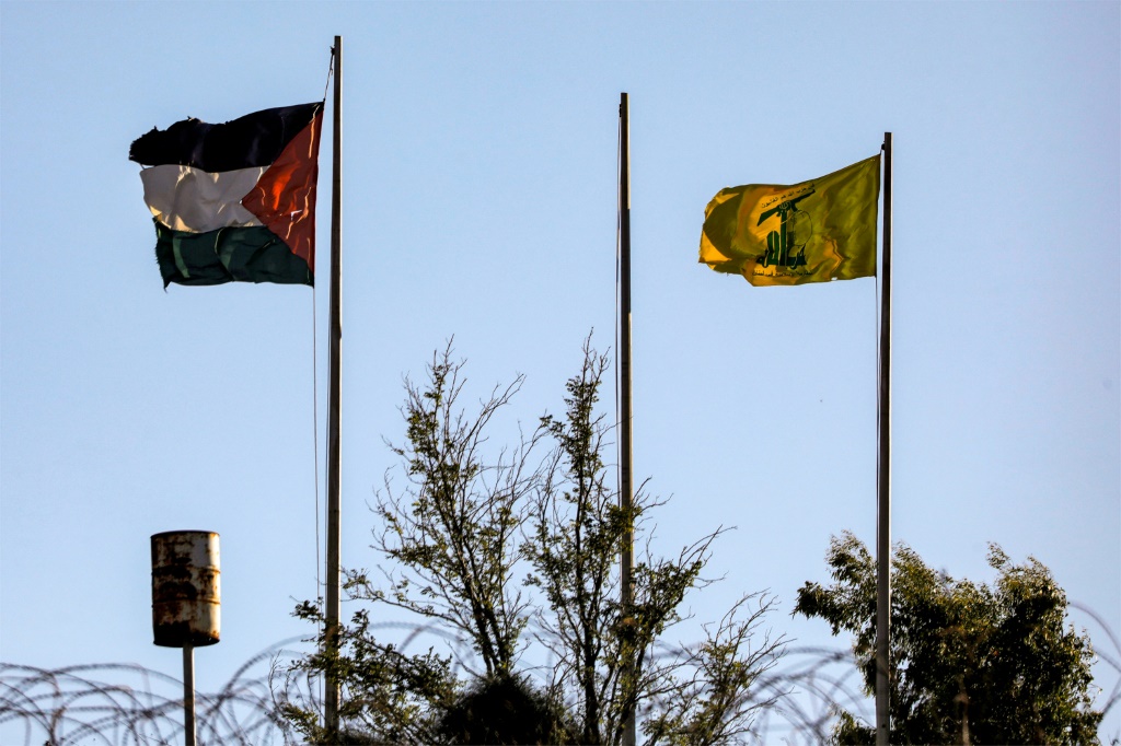 علم حزب الله اللبناني يجاوره علم فلسطين في المنطقة الحدودية الجنوبية مع اسرائيل (ا ف ب)