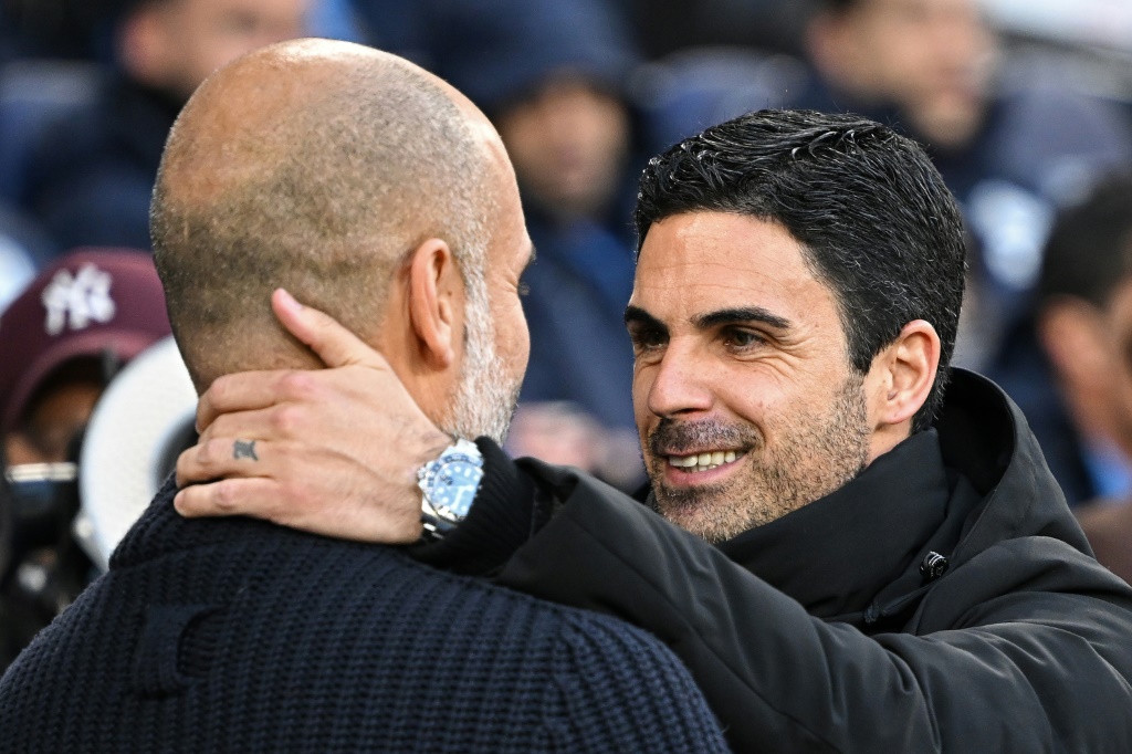 الإسباني بيب غوارديولا (إلى اليسار) مدرب مانشستر سيتي يحيي مواطنه ميكل أرتيتا مدرب أرسنال قبل مواجهتهما على ملعب الاتحاد في مانشستر، شمال غرب إنكلترا في 26 نيسان/أبريل 2023 (ا ف ب)