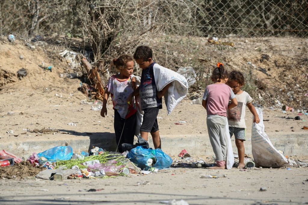 أطفال فلسطينيون ينقذون أشياء من القمامة وسط غزة (أ ف ب)   