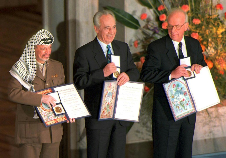 صورة مؤرخة في العاشر من كانون الأول/ديسمبر 1994 تُظهر الزعيم منظمة التحرير الفلسطينية ياسر عرفات ووزير الخارجية الإسرائيلي آنذاك شيمون بيريز ورئيس الوزراء الإسرائيلي إسحق رابين وهم يحملون جائزة نوبل للسلام الممنوحة لهم في أوسلو ( أ ف ب)