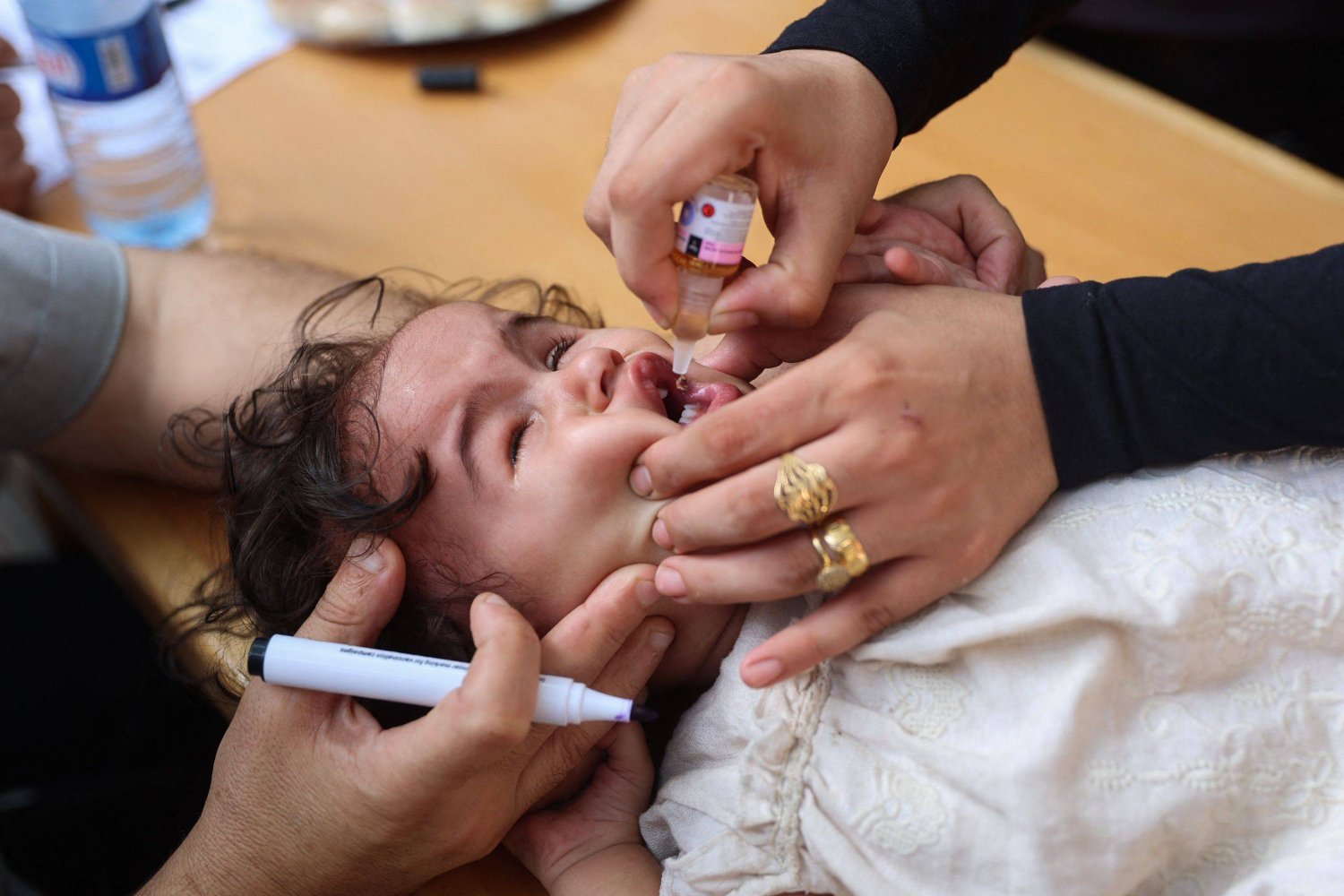 أطباء فلسطينيون يقدمون لقاحات شلل الأطفال في عيادة بمدينة غزة (أ.ف.ب)