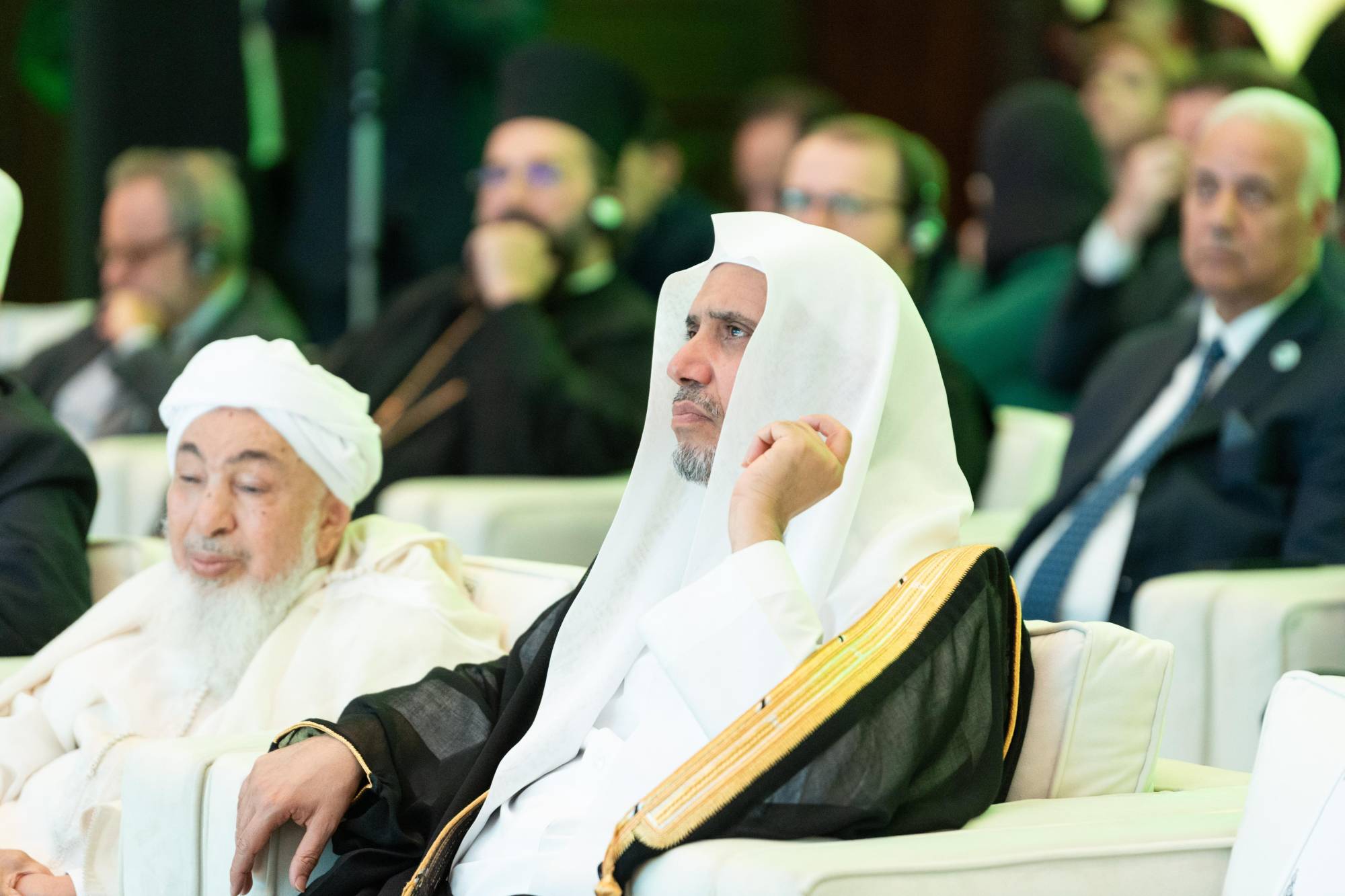 الدكتور محمد العيسى يستمع للكلمات خلال مؤتمر «الإيمان في عالم متغير» (الشرق الأوسط)
