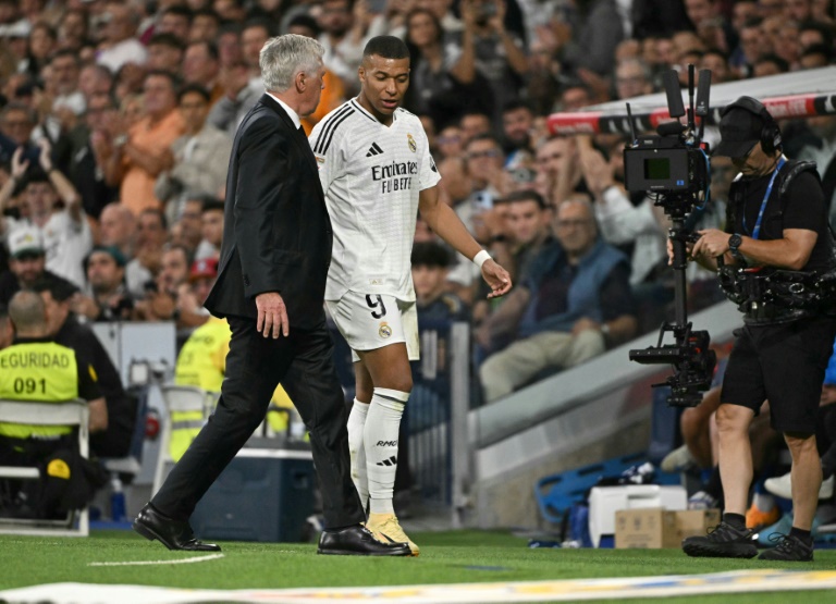 الإيطالي كارلو أنشيلوتي مدرب ريال مدريد (يسار) يتحدث مع الفرنسي كيليان مبابي مهاجم ريال مدريد الإسباني بعد خروجه من أرض الملعب في مواجهة ألافيس، ضمن الدوري الإسباني لكرة القدم. 24 أيلول/سبتمبر 2024 (أ ف ب)