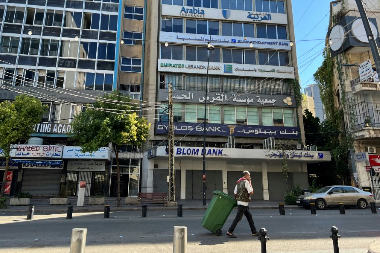 رجل يمر أمام مبنى يضم فرعا لجمعية القرض الحسن التابعة لحزب الله في مدينة صيدا في جنوب لبنان في 21 تشرين الأول/اكتوبر 2024 (ا ف ب)