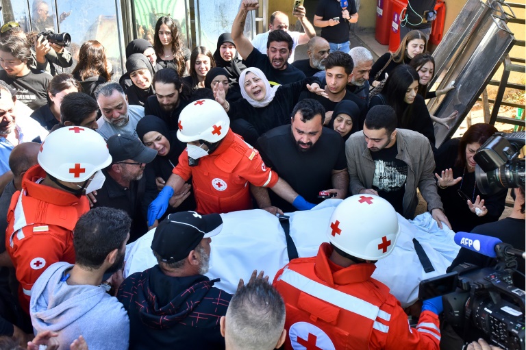 أفراد عائلات وزملاء ثلاثة صحافيين قتلوا بغارة اسرائيلية في جنوب لبنان فجر 25 تشرين الأول/أكتوبر 2024 لدى وصول جثثهم الى مستشفى في بيروت (أ ف ب)
