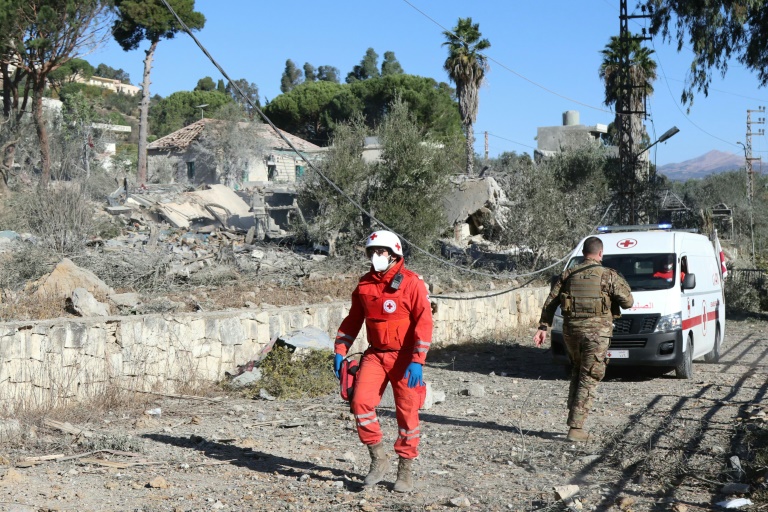 جندي من الجيش اللبناني ومسعف من الصليب الأحمر يتفقدان موقع غارة جوية إسرائيلية ليلية استهدفت قرية مرجعيون الجنوبية في 27 تشرين الأول/أكتوبر 2024 (ا ف ب)