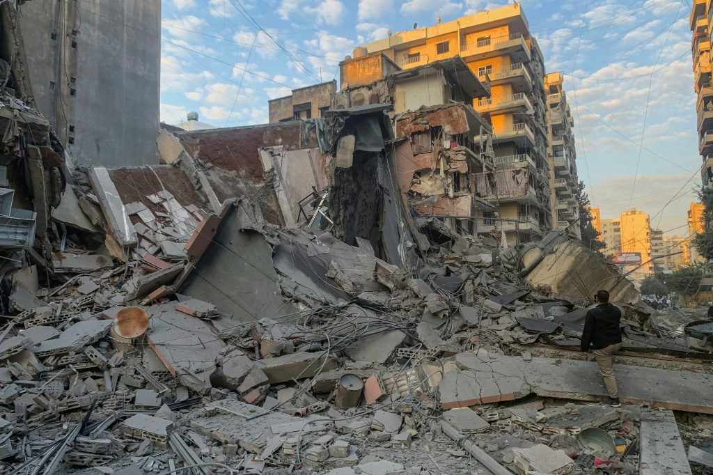 رجل يلتقط صورة للدمار في موقع غارة اسرائيلية على ضاحية بيروت الجنوبية في 7 تشرين الثاني/نوفمبر 2024. (أ ف ب)   