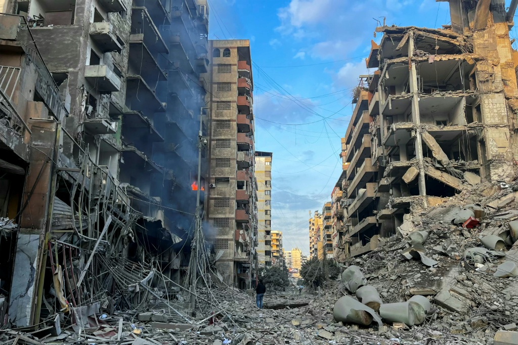 أشخاص يتفقدون الدمار في موقع الغارات الجوية الإسرائيلية التي استهدفت حي الرويس في الضاحية الجنوبية لبيروت في 9 تشرين الثاني/نوفمبر 2024 (أ ف ب)   
