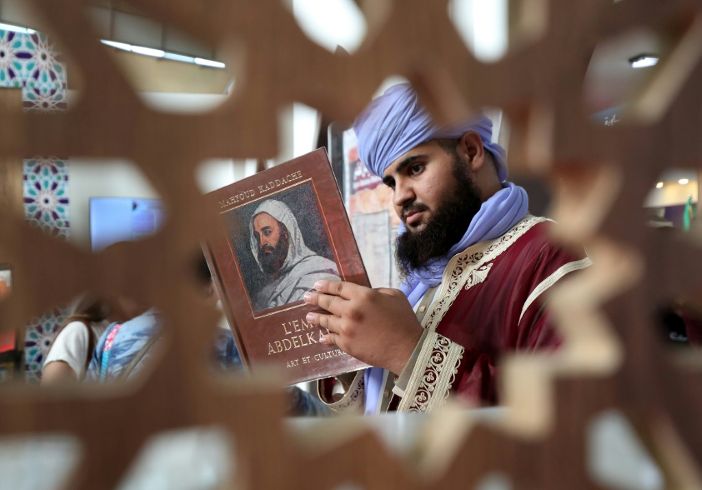 رجل يطالع كتابا في معرض الجزائر الدولي للكتاب في الجزائر العاصمة في الثامن من تشرين الثاني/نوفمبر 2024 (أ ف ب)   