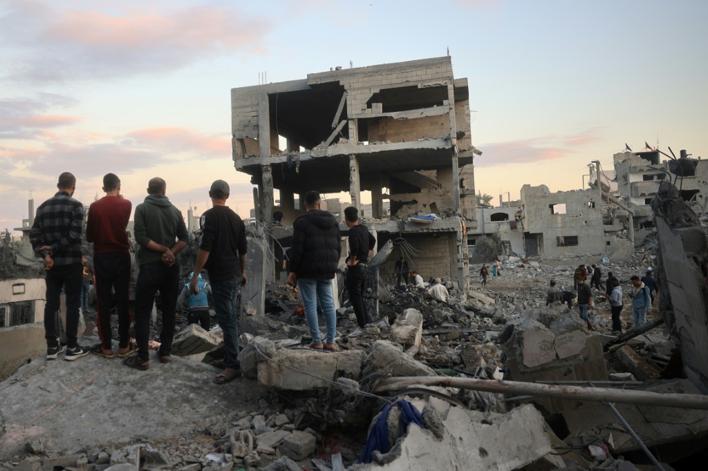 فلسطينيون يتفقدون الأضرار في موقع غارة جوية إسرائيلية على مخيم البريج للاجئين وسط قطاع غزة في 19 تشرين الثاني/نوفمبر 2024 (أ ف ب)   