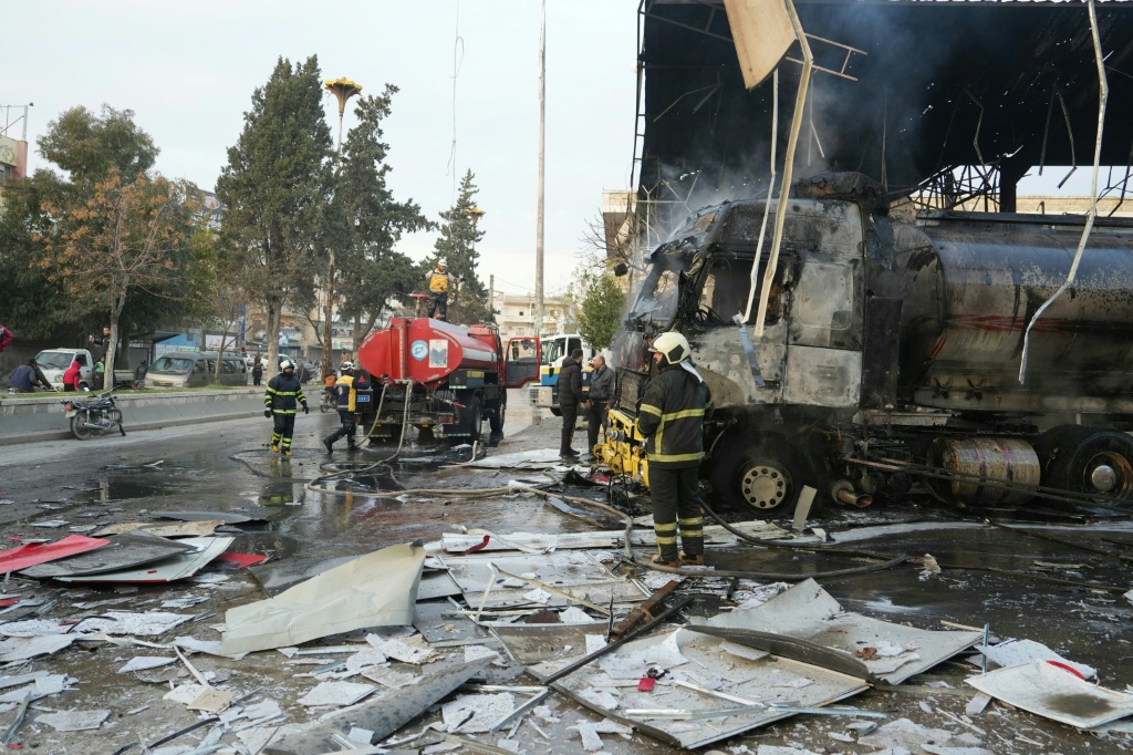 إطفائيون يخمدون النيران في شاحنة أصيبت بغارة جوية شنتها قوات النظام السوري في وسط مدينة إدلب في 29 تشرين الثاني/نوفمبر 2024 بينما تواصل هيئة تحرير الشام وفصائل متحالفة معها هجومها في محافظة حلب شمال سوريا ضد القوات الحكومية (أ ف ب)   