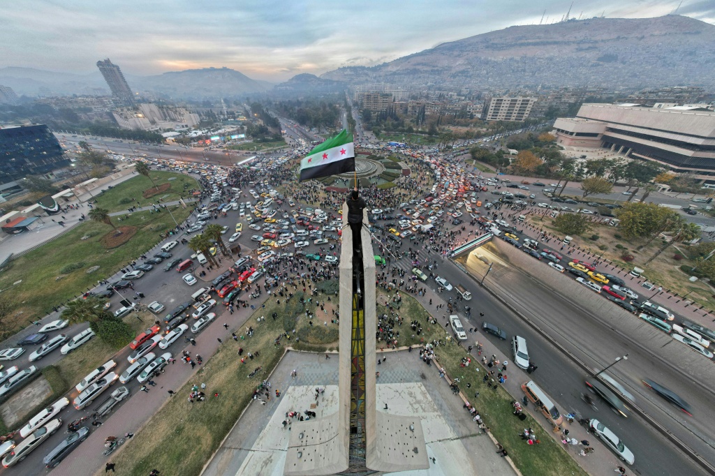 صورة جوية تظهر سوريا يلوح بعلم الاستقلال في ساحة الأمويين المركزية في دمشق في 11 كانون الأول/ديسمبر 2024 (أ ف ب)   