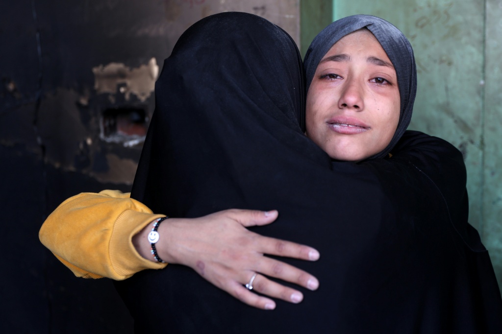 نساء يبكين بعد غارة إسرائيلية على مدرسة الماجدة وسيلة التابعة للأونروا والتي تؤوي فلسطينيين نازحين، في شارع الجلاء في مدينة غزة في 14 كانون الأول/ديسمبر 2024 (أ ف ب)   