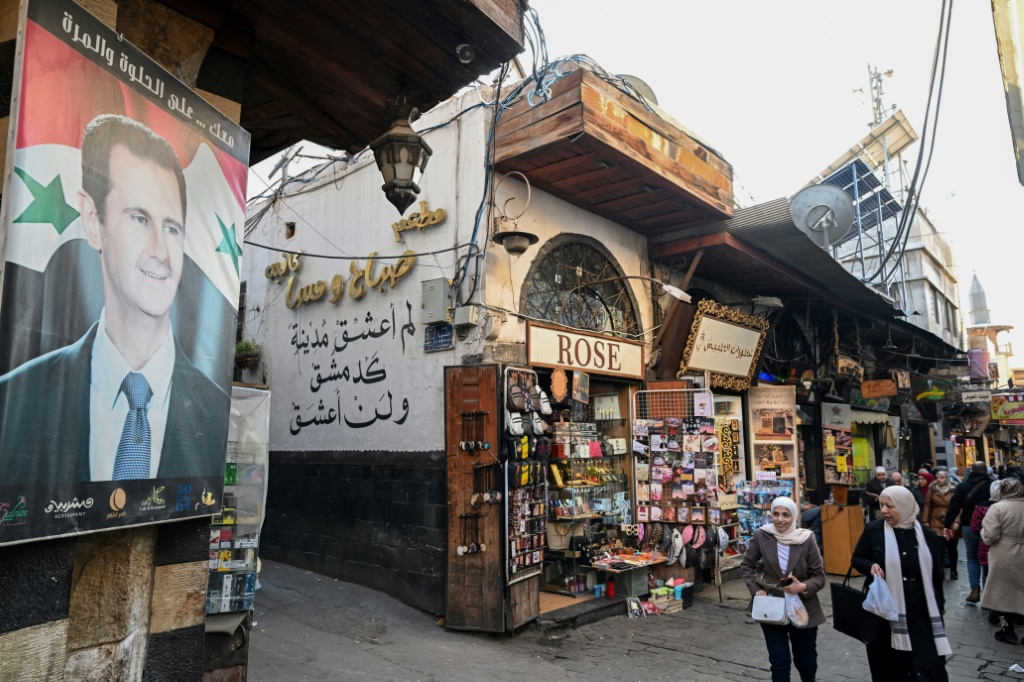 صورة عملاقة للرئيس السوري بشار الأسد في دمشق القديمة في السادس من كانون الأول/ديسمبر 2024 (أ ف ب)   