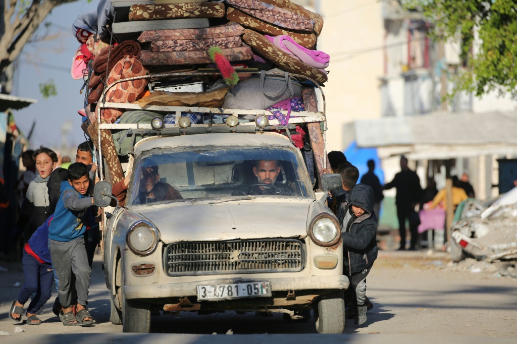 أطفال فلسطينيون يساعدون في دفع مركبة محملة بالوقود في مخيم البريج للاجئين في غزة بينما يفر السكان استجابة لأحدث تحذير للإخلاء من الجيش الإسرائيلي. (ا ف ب)   