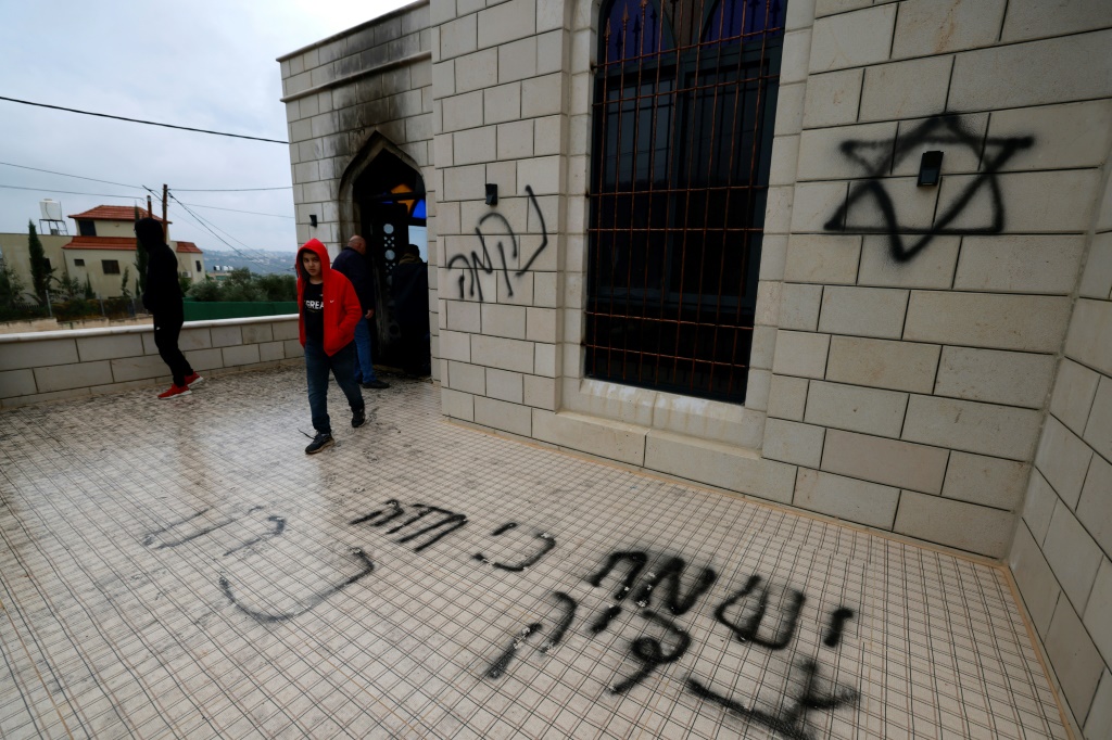 فلسطينيون يتفقدون الأضرار التي لحقت بمسجد هاجمه مستوطنون إسرائيليون في بلدة مردا شمال الضفة الغربية في 20 كانون الاول/ديسمبر 2024 (أ ف ب)   