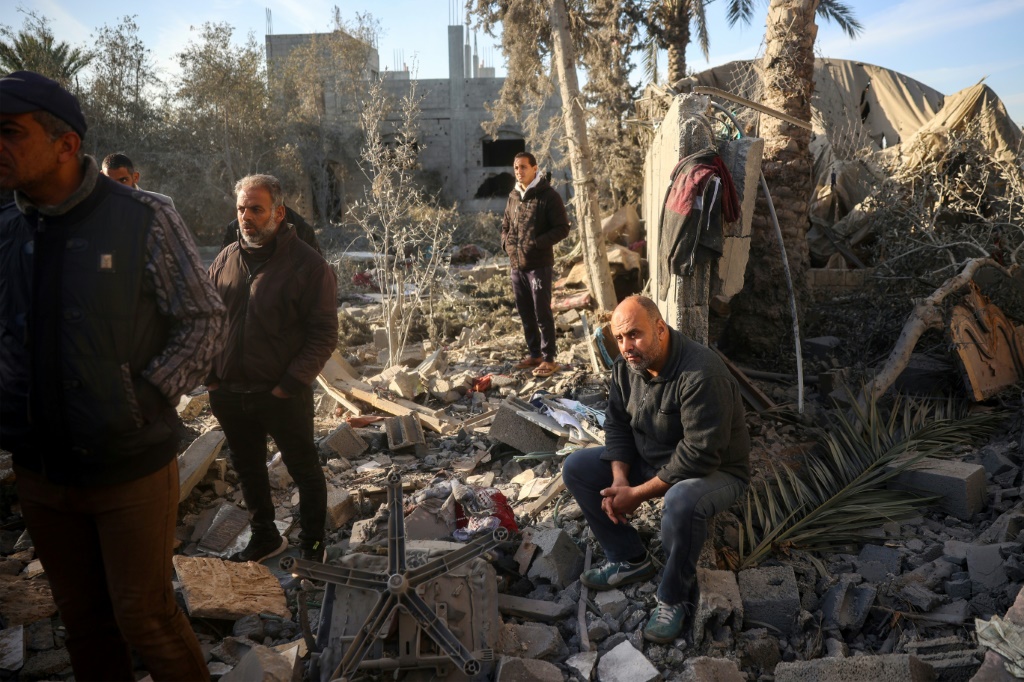 قريب لعائلة أبو سمرة يراقب البحث ن ناجين بعد غارة على منزل العائلة في وسط غزة (أ ف ب)   