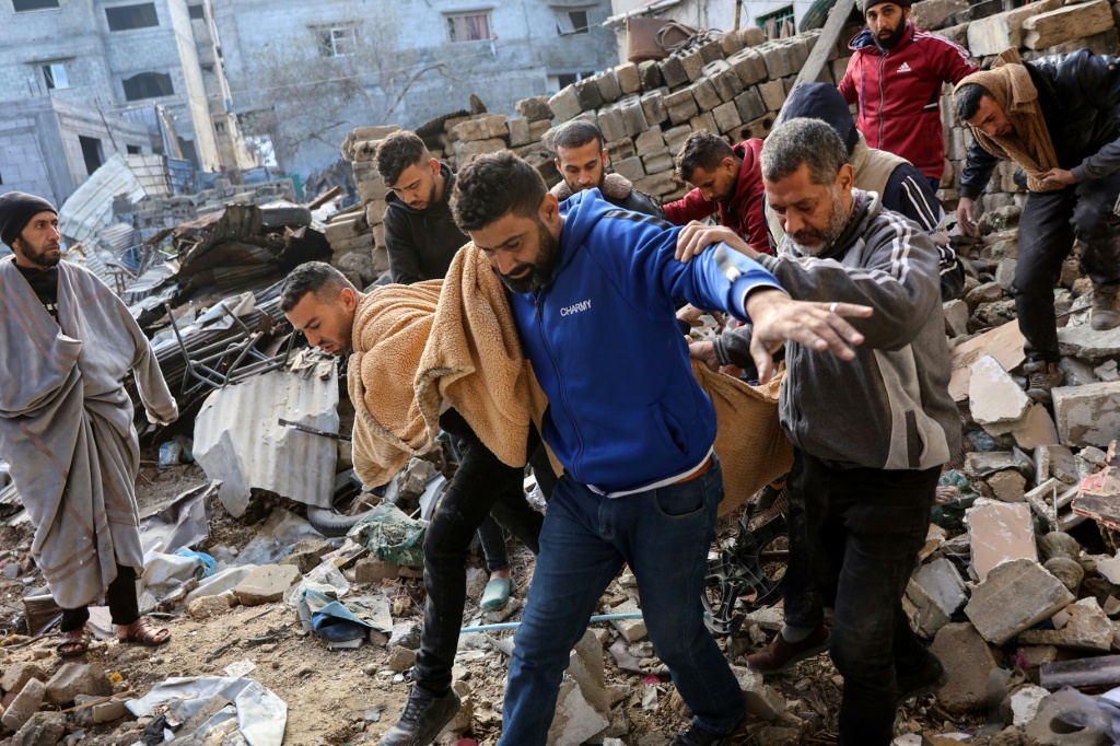 فلسطينيون ينتشلون جثة بعد غارة إسرائيلية على منزل في حي الشجاعية بمدينة غزة في الرابع من كانون الثاني/يناير 2025 (أ ف ب)   