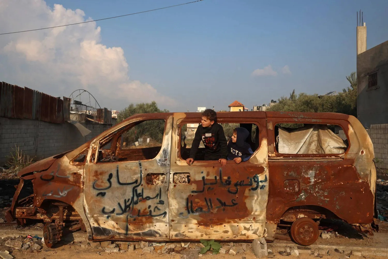 صبي فلسطيني يلعب داخل سيارة دمرتها غارة جوية إسرائيلية في مدينة غزة السبت (أ.ف.ب)