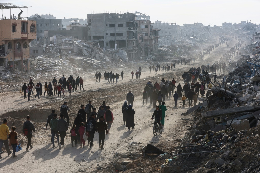 عشرات النازحين الفلسطينيين يتوجهون إلى جباليا بشمال قطاع غزة للعودة إلى منازلهم في 19 كانون الثاني/يناير 2025 مع دخول وقف إطلاق النار حيز التنفيذ بين إسرائيل وحركة حماس (أ ف ب)   