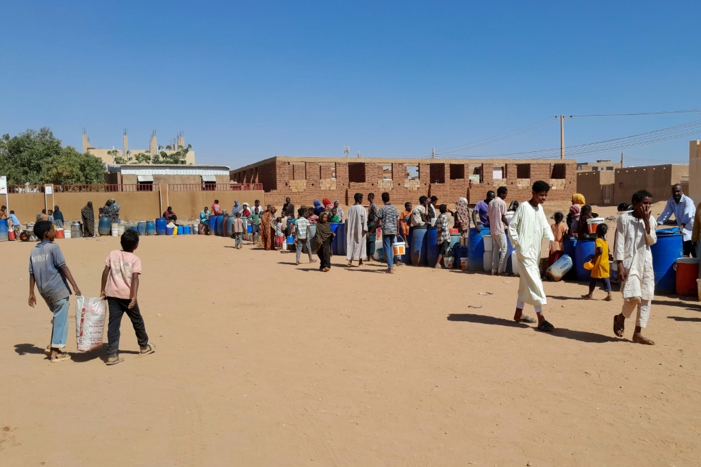 سودانيون يصطفون للحصول على المياه في أم درمان، وهي جزء من منطقة الخرطوم الكبرى حيث يخوض الجيش السوداني وقوات الدعم السريع شبه العسكرية صراعا طويلا من أجل السيطرة. (أ ف ب)   