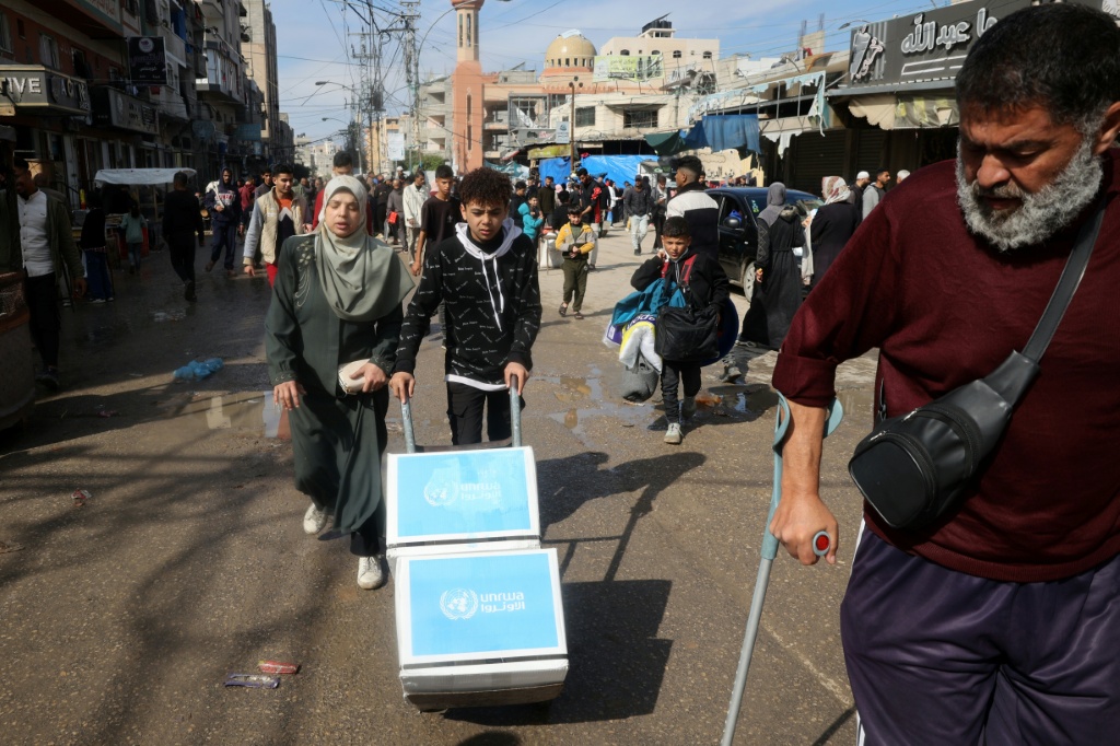    فتى فلسطيني ينقل صناديق من المساعدات الإنسانية في النصيرات في قطاع غزة بتاريخ 26 كانون الثاني/يناير 2025 (أ ف ب)   