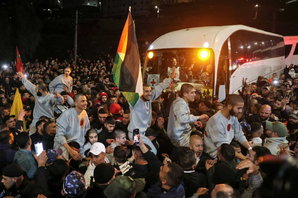 حشد يحيي فلسطينيين أفرجت عنهم إسرائيل لدى وصولهم في حافلة تابعة للصليب الأحمر الدولي في رام الله بالضفة الغربية المحتلة في 30 كانون الثاني/يناير 2025 (أ ف ب)   
