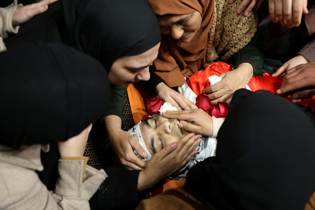 أهالي الفلسطيني محمد حدوش (27 عاما) الذي قُتل الأحد خلال مواجهات مع قوات الاحتلال الإسرائيلي يودعونه خلال تشييعه في مخيم العروب للاجئين الفلسطينيين جنوب بيت لحم بالضفة الغربية المحتلة، في 3 شبط/فبراير 2025 (أ ف ب)   