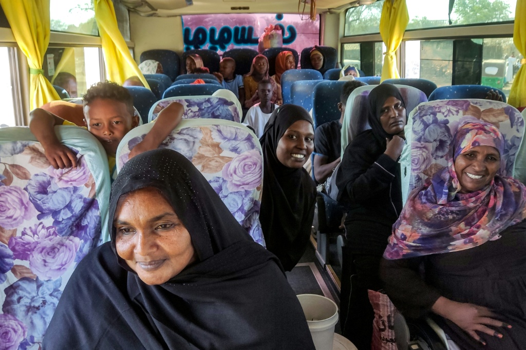 نساء على متن حافلة تقل نازحين بسبب الحرب الدائرة في السودان وهم في طريقهم من مدينة القضارف بشرق البلاد في 3 شباط/فبراير 2025 إلى مدينتهم ود مدني في ولاية الجزيرة بعد أن استعادها الجيش السوداني (أ ف ب)   