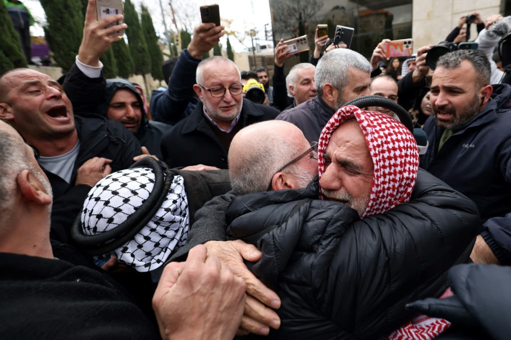 معتقل فلسطيني تم الافراج عنه يعانق احد افراد عائلته في مدينة رام الله بالضفة الغربية المحتلة في الثامن من شباط/فبراير 2025 (أ ف ب)   