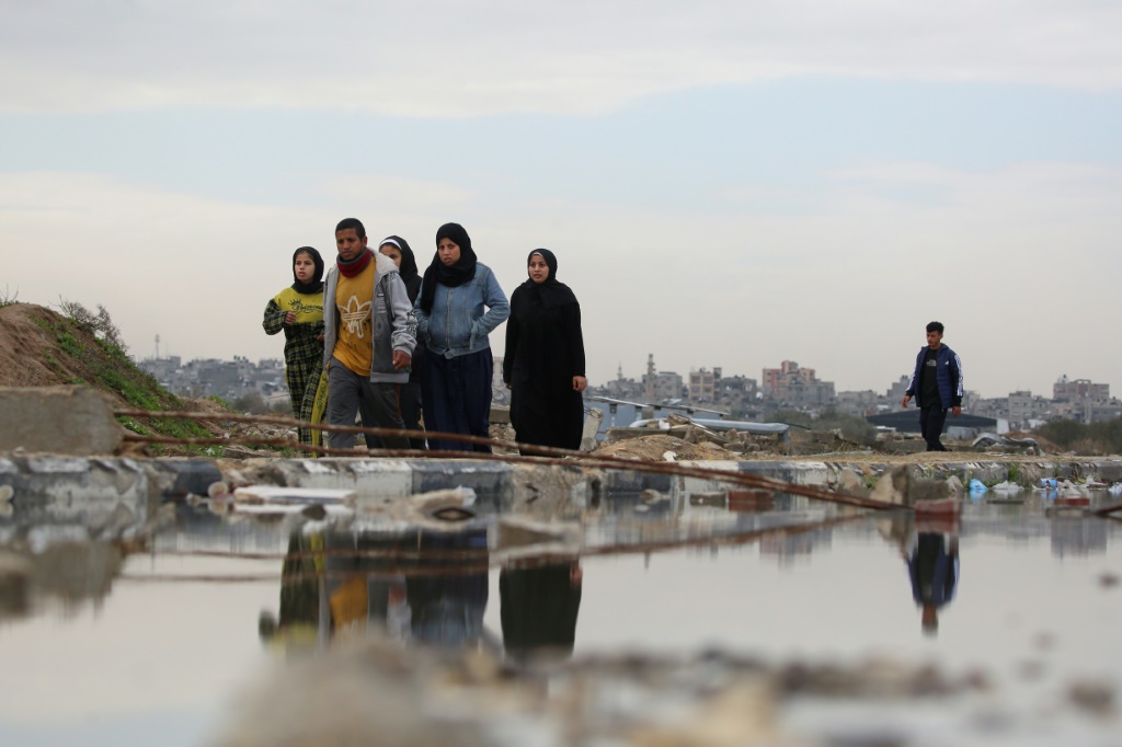 مدنيون فلسطينيون يسيرون في منطقة المغراقة في وسط قطاع غزة في 13 شباط/فبراير 2025 (أ ف ب)   