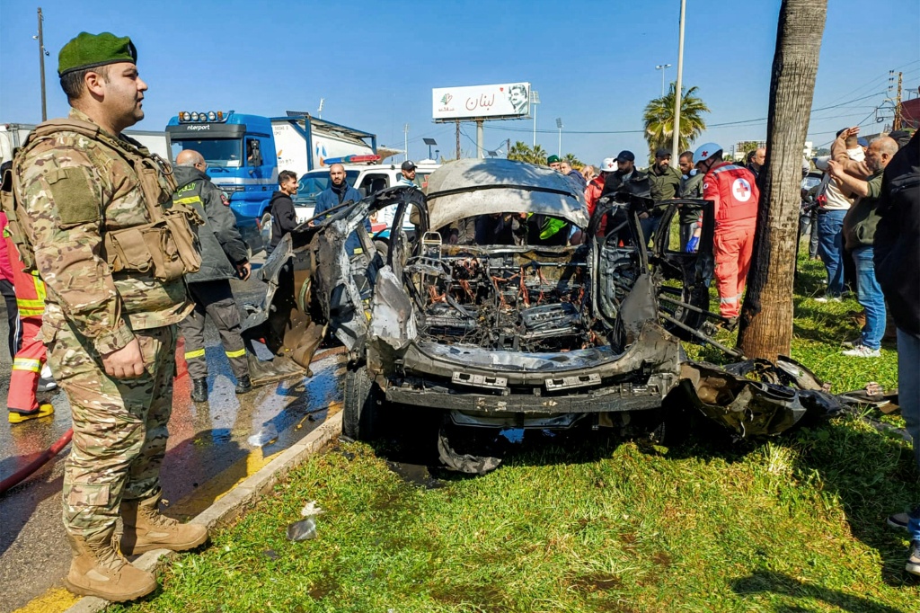 عنصر من الجيش والقوى الأمنية والدفاع المدني يتفقدون سيارة استهدفتها غارة إسرائيلية في صيدا في جنوب لبنان في 17 شباط/فبراير 2025 (أ ف ب)   