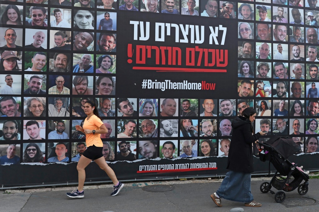 ملصق يضم صور رهائن إسرائيليين محتجزين في قطاع غزة، في القدس في 17 شباط/فبراير 2025 (أ ف ب)   