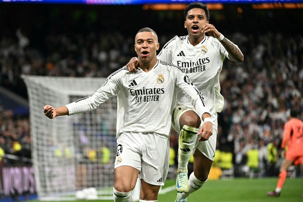 المهاجم الفرنسي لريال مدريد الإسباني كيليان مبابي (يسار) يحتفل مع زميله البرازيلي رودريغو (يمين) بتسجيل هدف فريقه الثاني في مرمى مانشستر سيتي الإنكليزي ضمن المحلق المؤهل إلى ثمن نهائي دوري أبطال أوروبا لكرة القدم على ملعب سانتياغو برنابيو، مدريد، في 19 شباط/فبراير 2025 (أ ف ب)   