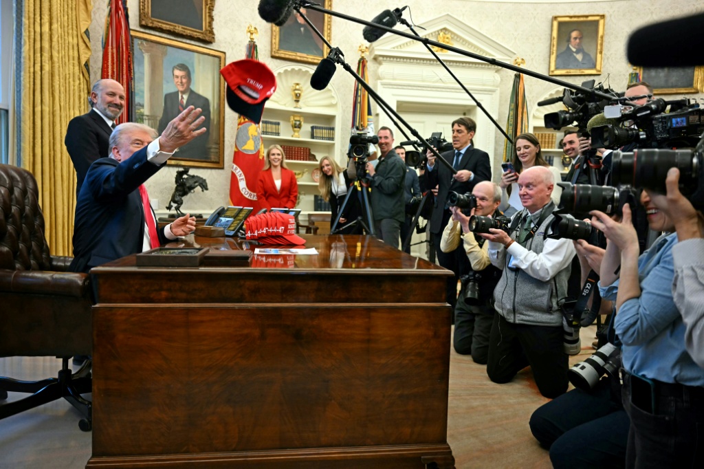 الرئيس الأميركي دونالد ترامب يلقي قبعة بيسبول كتب عليها "ترامب كان محقا في كل شيء" في المكتب البيضاوي بتاريخ 25 شباط/فبراير 2025 (ا ف ب)   